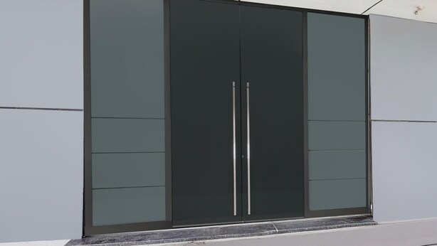 A modern building with a large, dark-colored sliding door and a flat roof. - Deluxe Krishna Janam Bhoomi (Mathura)