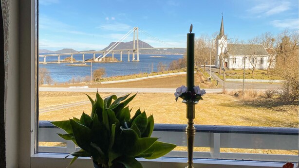 En utsikt från ett fönster med utsikt över en flod, en bro och en kyrka.