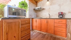 Une cuisine avec des meubles de rangement en bois, un four à micro-ondes encastré et une machine à café.