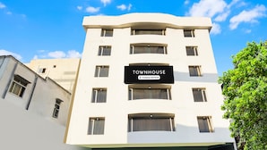 Een meerlaags gebouw met een bord waarop 'TOWNHOUSE Company Serviced' staat.