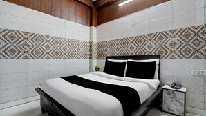 Ein modernes Hotelzimmer mit einem Bett, einem Nachttisch und einer kleinen Pflanze.