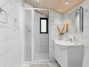 A modern bathroom with a shower, a sink with a mirror, and a window. - "Emelita" - 1.1km from the sea by Interhome (Græsted)