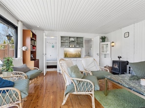 A cozy room with a bed, two wicker chairs, a table, a bookshelf, a cabinet, and a fireplace. - "Emelita" - 1.1km from the sea by Interhome (Græsted)