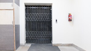 Ein schwarzes Metalltor mit an der Seite angebrachtem Feuerlöscher.