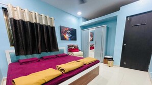 Un dormitorio con cama, armario, puerta y ventana con cortinas.