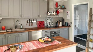Moderni keittiö, jossa on harmaat kaapit, puinen työtaso ja punainen matto.