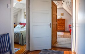 Ein Zimmer mit einem Bett, einem Schminktisch und einem roten Stuhl.