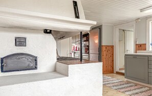 Een keuken met witte wanden, een inbouwfornuis en een houten vloer.