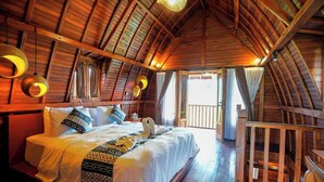 Una habitación de madera con una cama, una ventana y vistas al exterior.