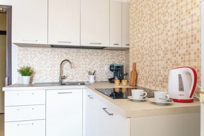 Eine Küche mit Spüle, Kaffeemaschine, Toaster und einer Pflanze.
