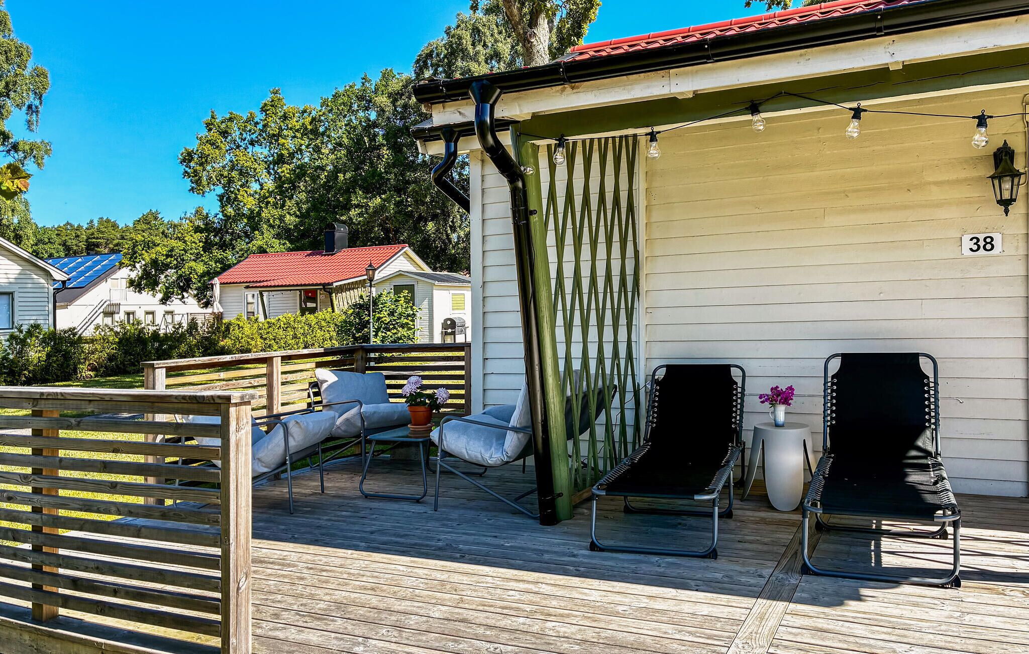 Eine Terrasse mit Sitzgelegenheit, einer Pergola und einem Gebäude mit der Nummer 38.