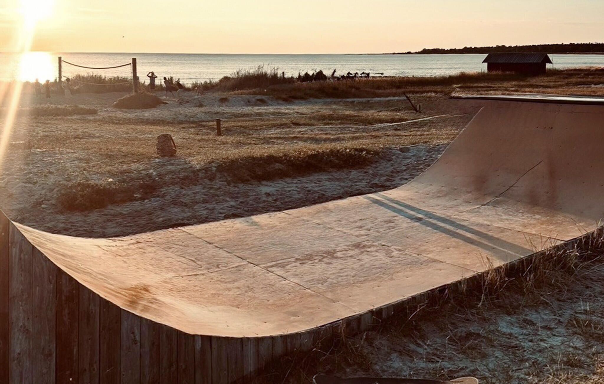 Un parco di skate con una rampa e un corpo d'acqua sullo sfondo.