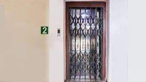 A door with a number '2' sign, a security gate, and a wall-mounted device. - Deluxealpine Glow Pinnacle (Hyderabad)