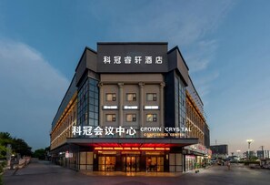 A hotel with a modern architectural design, featuring a prominent entrance with glass doors and a sign indicating it is the Crown Crystal Conference Center. - KEGUAN RUIXUAN HOTEL (Shanghai)