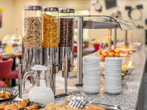A buffet setup with various food options, a pitcher of milk, and stacked white plates. - 2 Person Holiday Park Home in Erlbach (Markneukirchen)
