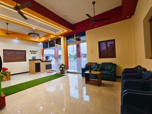 A reception area with a reception desk, seating, and a view through the glass doors.