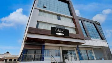 A modern building with a sign reading 'Collection' and a staircase leading to the entrance.