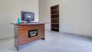 A reception desk with a sign reading 'HOTEL,' a computer, and a bottle of hand sanitizer.