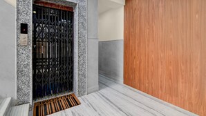 An elevator with a metal gate, a digital display, and a doormat with 'WELCOME' on a marble floor. - Premium Super Collection O Tollygunge (Kolkata)
