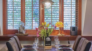 A dining table set with plates, glasses, and a vase of flowers. - Beautiful cozy home in a wooded holiday park. (Rekem)