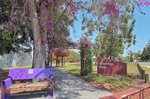 Un banco de parque, una pérgola y un cartel que indica Silvertop Park.