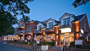 A multi-story hotel with balconies, outdoor seating, and a stone facade. - 2 Person Holiday Park Home in Heikendorf (Heikendorf)