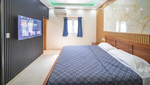 A hotel room with a bed, a television mounted on the wall, and a ceiling fan. - Compai Unit 7 Home AC, Wifi, Prime Location (Sosúa)