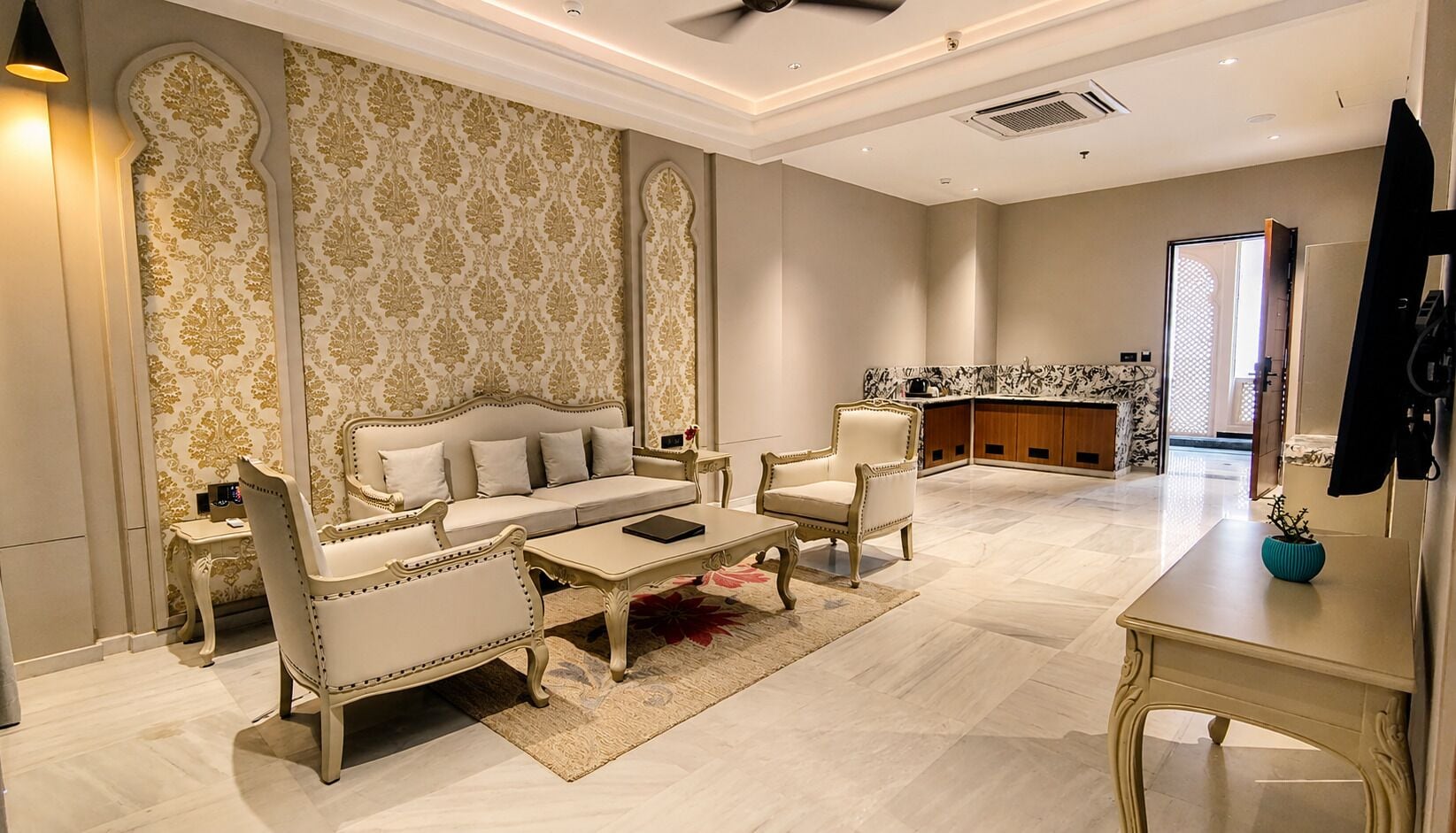 Un salón amplio con sofá, sillones, una mesa de centro y televisor.