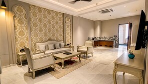 Un salón amplio con sofá, sillones, una mesa de centro y televisor.