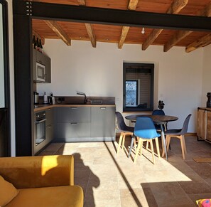 A modern kitchen with grey cabinets, a built-in oven, and a window overlooking a snowy landscape. - Beautiful countryside house, 40 minutes from Sarlat / Gourdon / Cahors (Goujounac)