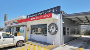 Ein Drive-In-Kaffee mit einem 7-Eleven-Schild und einem großen Kaffeeschild.