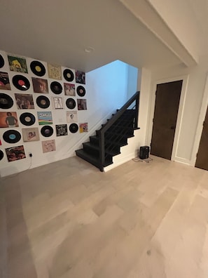 A staircase with a wall decorated with vinyl records and album covers.