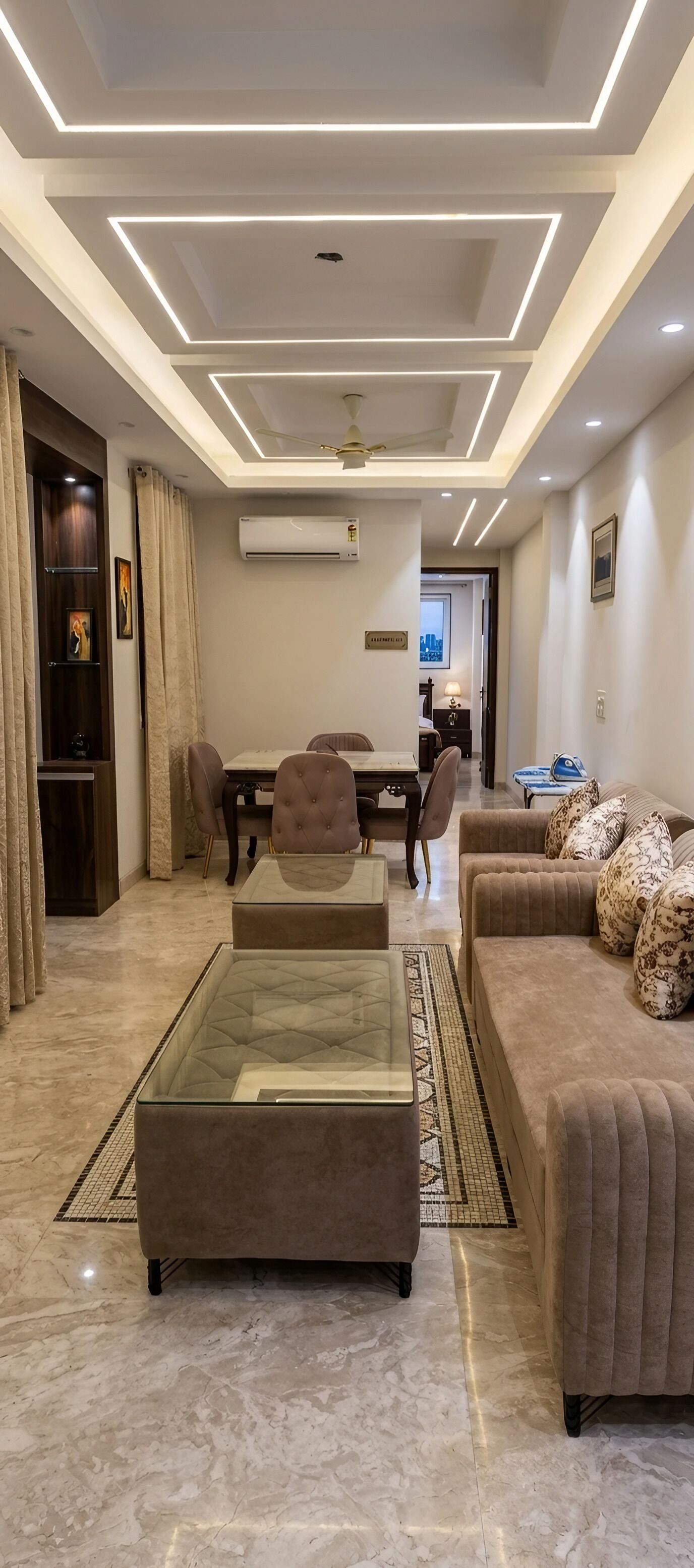 A modern living room with a glass coffee table, a sofa, and a dining area with chairs.