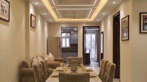 A dining area with a marble floor, a central table set for six, and a ceiling fan.