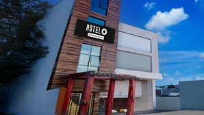 A modern hotel with a prominent sign, a wooden facade, and a clear sky. - Premium Hotel O IIM Road Lucknow (Bakshi Ka Talab)