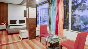 A bedroom with a bed, bedside table, and a window with curtains.