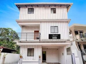 A multi-story building with a balcony, a door, and a sign that reads 'Collection.'