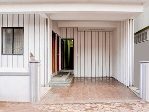 A hallway with a tiled floor and vertical paneling on the walls.