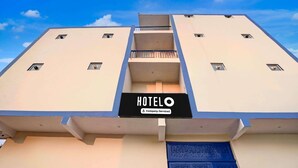 A hotel with a sign reading 'HOTELO' and a blue door. - Super Hotel O SGT University Road (Gurugram)