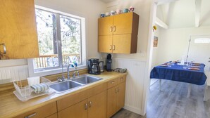 A kitchen with wooden cabinets, a double sink, and a coffee maker.