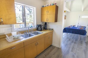 A kitchen with wooden cabinets, a double sink, and a coffee maker. - Wishon Cabin - Boat Slip - BBQ, Sleeps 14, Dogs Ok (Wishon)