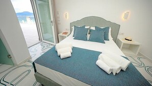 A hotel room with a bed, two bedside tables, a large window with a view, and a door leading outside. - Villa Sirenea: A splendid and luminous three-story villa located right on the beach, with Free WI-FI. (Vico Equense)