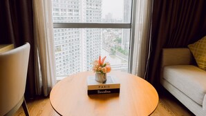 Una habitación con un ventanal grande, una mesa con un libro titulado 'PARIS Barcelona' y un sofá.