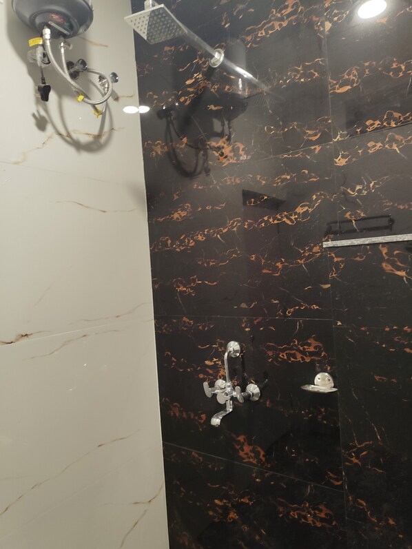 A bathroom with a shower, a toilet, and a sink. - Hotel Kashi Bliss (Varanasi)