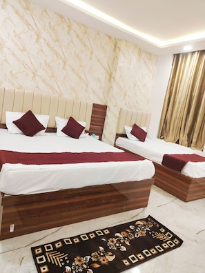 A hotel room with a marble-patterned wall, two beds with wooden headboards, and a decorative rug. - Hotel Kashi Bliss (Varanasi)