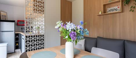 A modern kitchen with a refrigerator, a wooden cabinet, and a decorative sign on the wall.