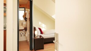 A bedroom with a bed, bedside table, and a view of the bathroom. - GuestHouse Mainz (Mainz)