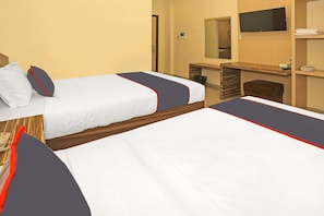 Une chambre d’hôtel avec deux lits, un bureau, une télévision et une salle de bain.