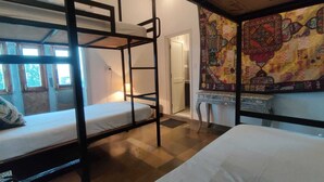 A room with bunk beds, a patterned tapestry, and a door leading to another room. - Jarokha Haveli  (Udaipur)
