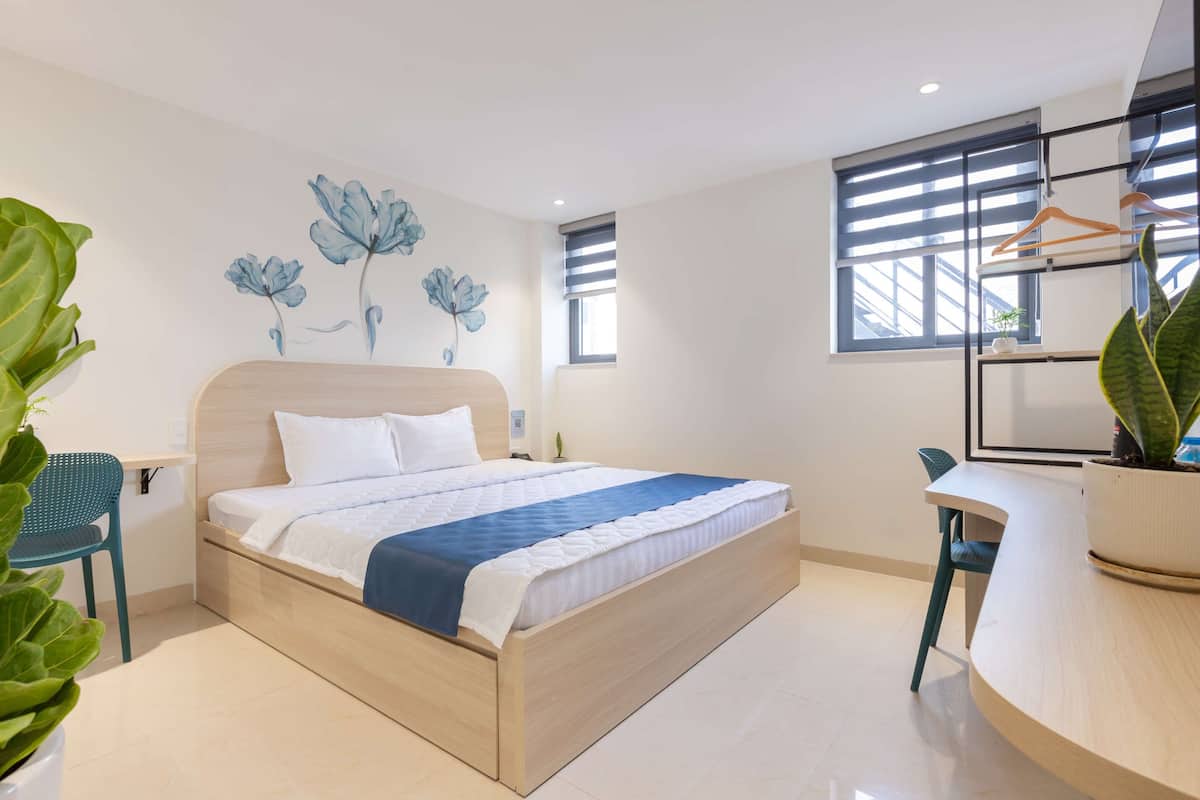 Ein modernes Schlafzimmer mit einem Holzbett, einem Schreibtisch und einem Blumentopf.